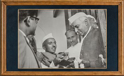 1952 archival photograph of Govindji Gajjar presenting a silver cigarette case to Jawaharlal Nehru